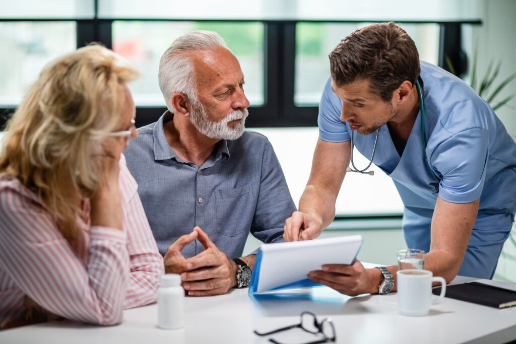 Doctor discussing Medicare options with a senior couple during an insurance consultation.